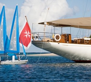 Tiziana at anchor and sailing dinghies