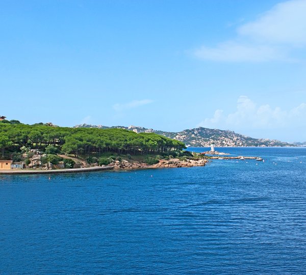 Porto Faro With The Pinewood Tiny Lighthouse And Rocky Mountains On The Background Palau Sardinia Italy
