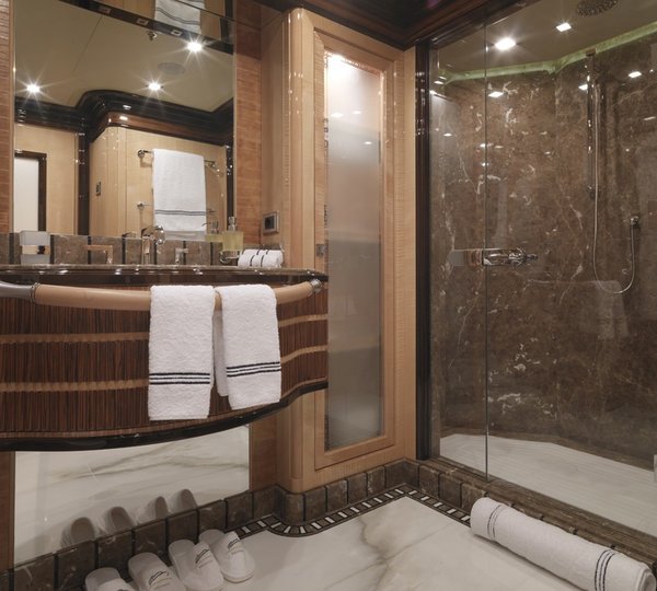 ensuite bathroom with marble walls and flooring and built-in luxury furniture