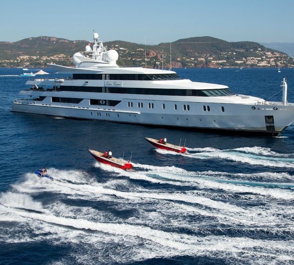 superyacht at anchor with tenders running