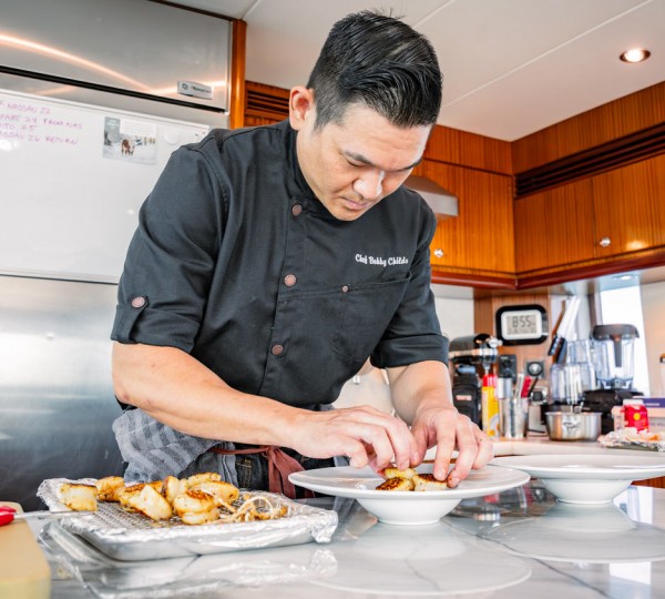 Chef Plating In Galley On Yacht