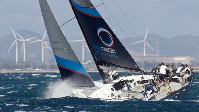 TeamOrigin TP52 on the final day of the Audi MedCup 2010. The team which stood for raising awareness of climate change heads fittingly into a backdrop of wind-turbines off the Italian coast -  Ian Rom