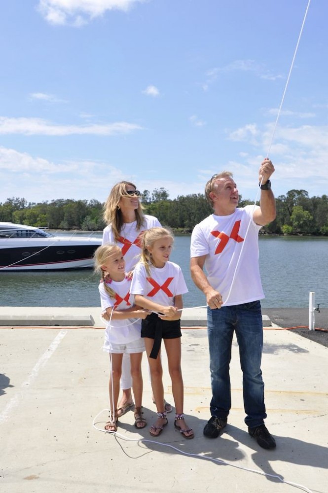 Russell Ingall and family hoist the giant X flag to mark the opening of the Gold Coast Marine Expo