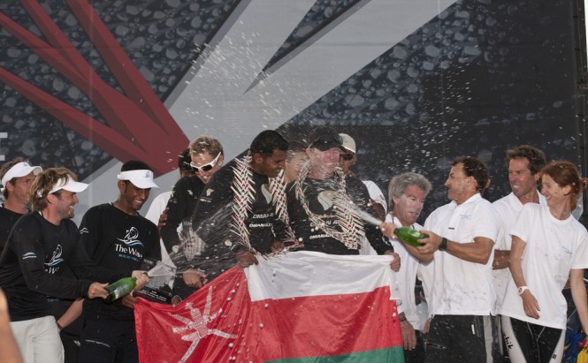 Leigh McMillan and Pierre Pennec spray champagne over winning skipper Morgan Larson at the prizegiving Credit Lloyd Images