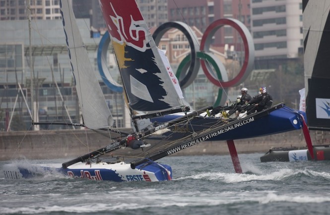 Red Bull Sailing Team flying a hull in front of the Olympic rings - Photo Lloyds Images