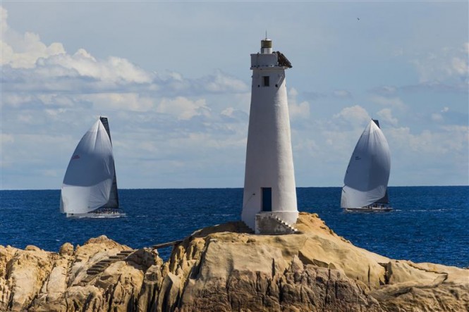 Luxury yachts Shockwave and Ran approach the lighthouse at Monaci - Photo by Rolex Carlo Borlenghi