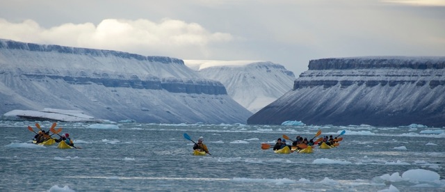 Members of EYOS Expeditions kayaking amidst beautiful Arctic scenery