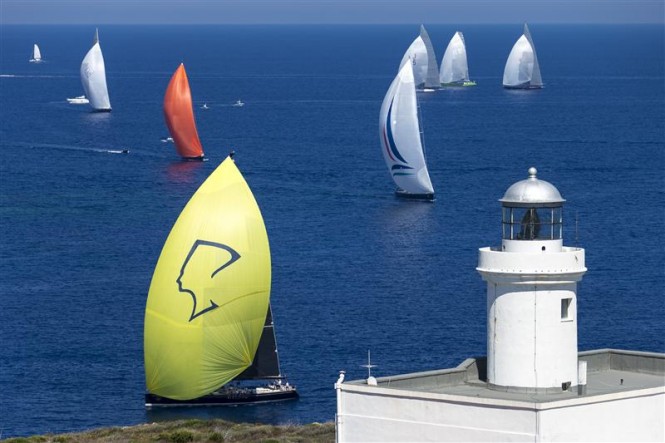 Super maxi and J classes sail pass Capo Ferro during the first day of racing