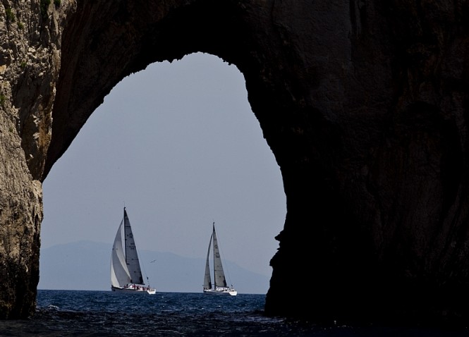 Competitors pass by the Faraglioni Rock formations off the south-east coast of Capri - Image by Rolex Carlo Borlenghi