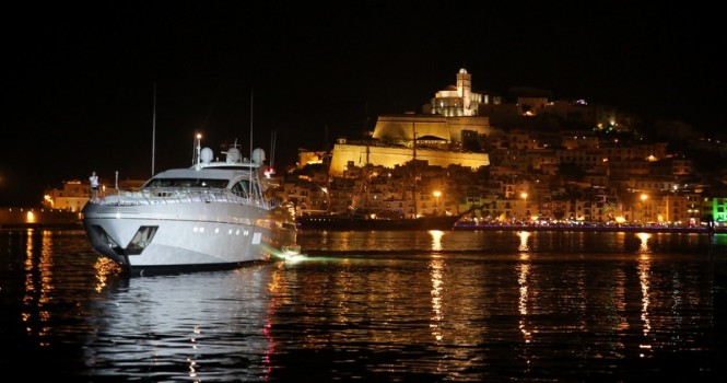 Luxury motor yacht by Mangusta at Marina Ibiza by night