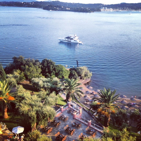 The 75 Yacht FINEZZA pictured in the morning of the event, with beautifully still waters and the stunning Corfu Imperial Hotel nearby