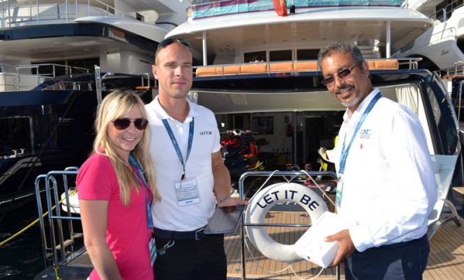 Costas from GMC and Michelle from Yachting Pages handing an iPad mini to Lucas from motor yacht Let it Be