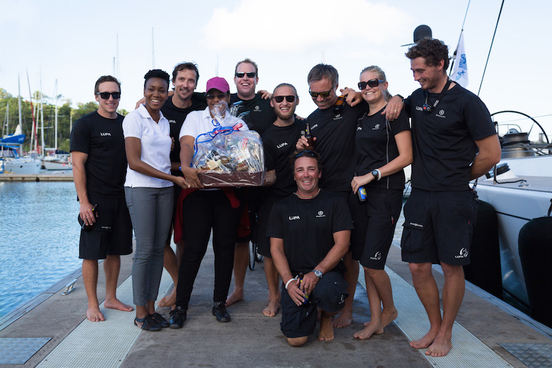 Overall winners and first recipients of the RORC Transatlantic Race Trophy as well as the IMA Trophy for Line Honours - charter yacht Lupa of London's crew enjoy a warm Grenadian welcome and a huge basket of local goodies on arrival