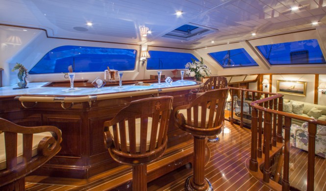 Whisper’s teak interior is adorned with intricate inlays and carvings and includes an upper pilothouse lounge (left) that boasts a full wet bar with panoramic views of the horizon 
