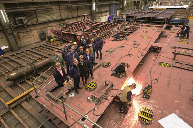 The BlohmVoss Development Team inspects the progress of one of three brand new hull sections of the BV80 in the construction hall at the shipyard in Hamburg