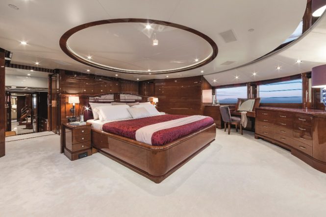 Spacious master stateroom with plush furnishings and elegant wooden furniture
