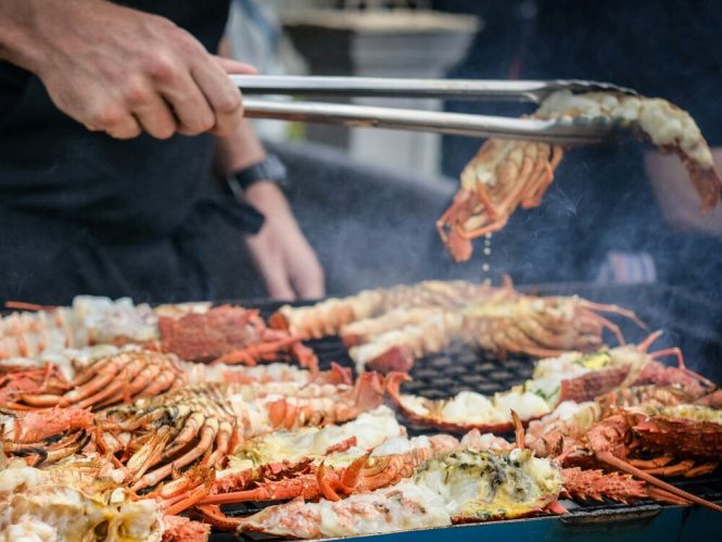 Chef preparing grilled seafood for guests