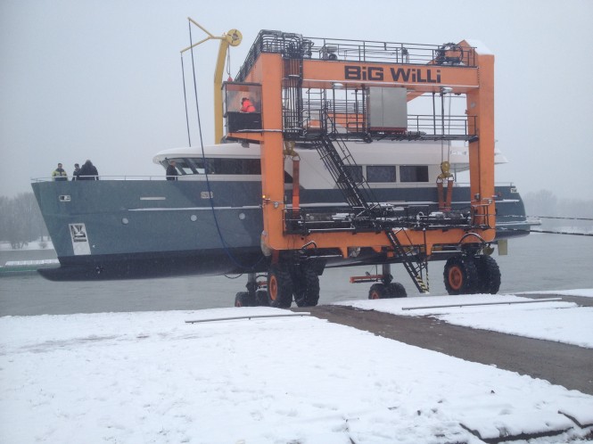 The travellift moves sideways out of the river and loads to a road transporter for the final part of the journey into the Dusseldorf Boat Show The travellift moves sideways out of the river and loads to a road transporter for the final part of the journey into the Dusseldorf Boat Show